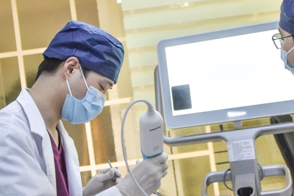 Two male dentists in a dental clinic looking at a screen.