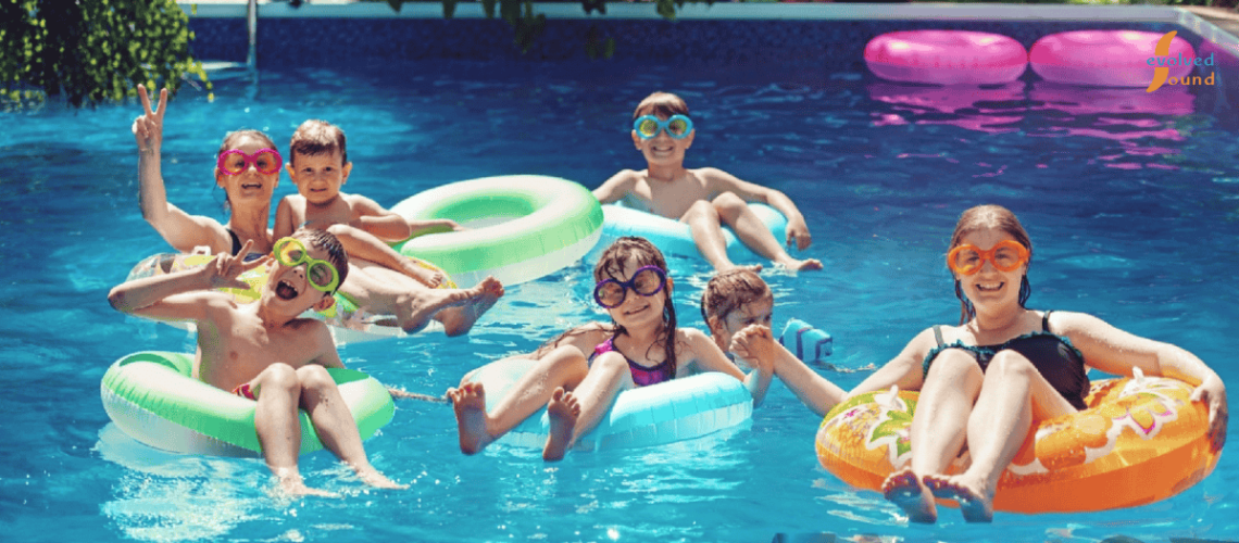 Children playing on floating devices in a public aquatic leisure centre.